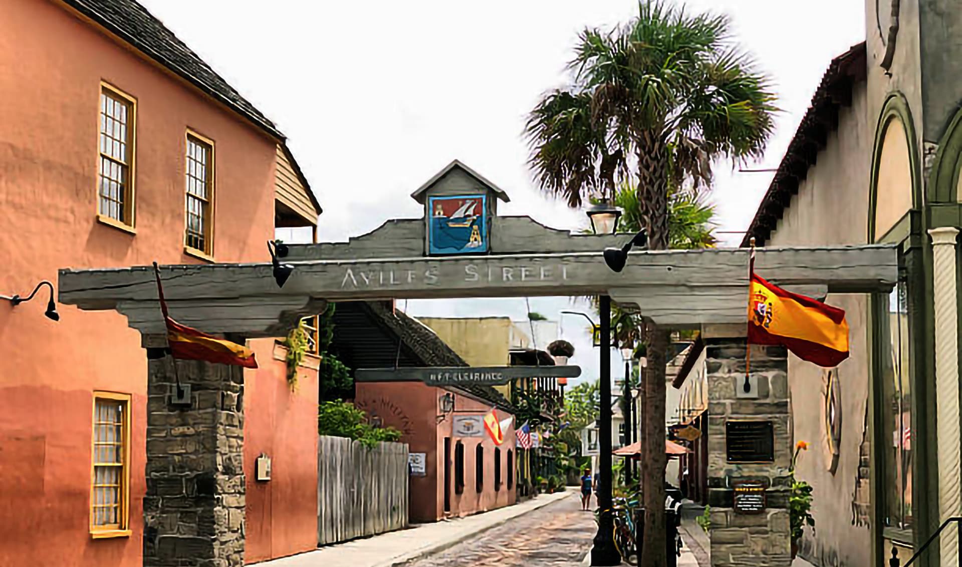 View of Aviles Street, featuring colorful buildings and palm trees.
